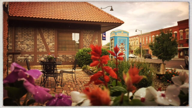 lindsborg-kansas-downtown-morning-summer Morning light on downtown Lindsborg with flowers in the foreground and brick storefronts along the street.