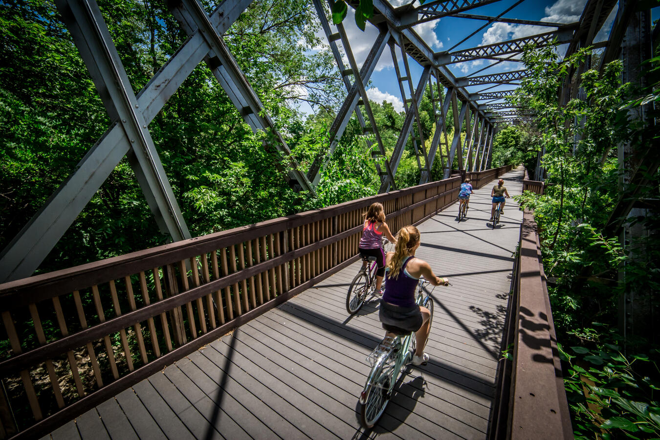lindsborg-kansas-valkommen-trail-bridge A pedestrian and cyclist bridge surrounded by lush greenery along the Välkommen Trail in Lindsborg.