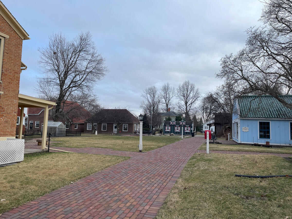Historic buildings in Pella’s Vermeer Village along a brick walkway with winter trees.