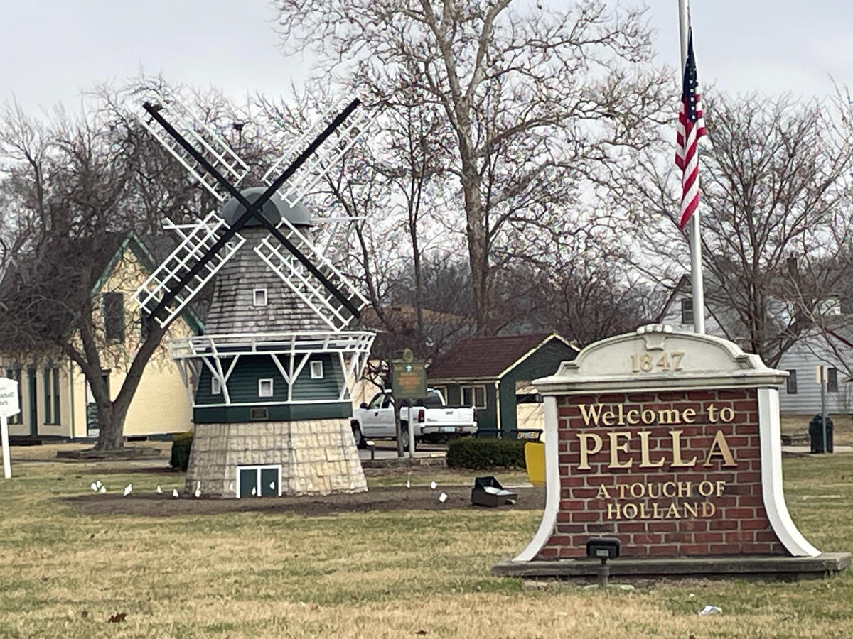 Brick ‘Welcome to Pella’ sign and small windmill structure near the town entrance.