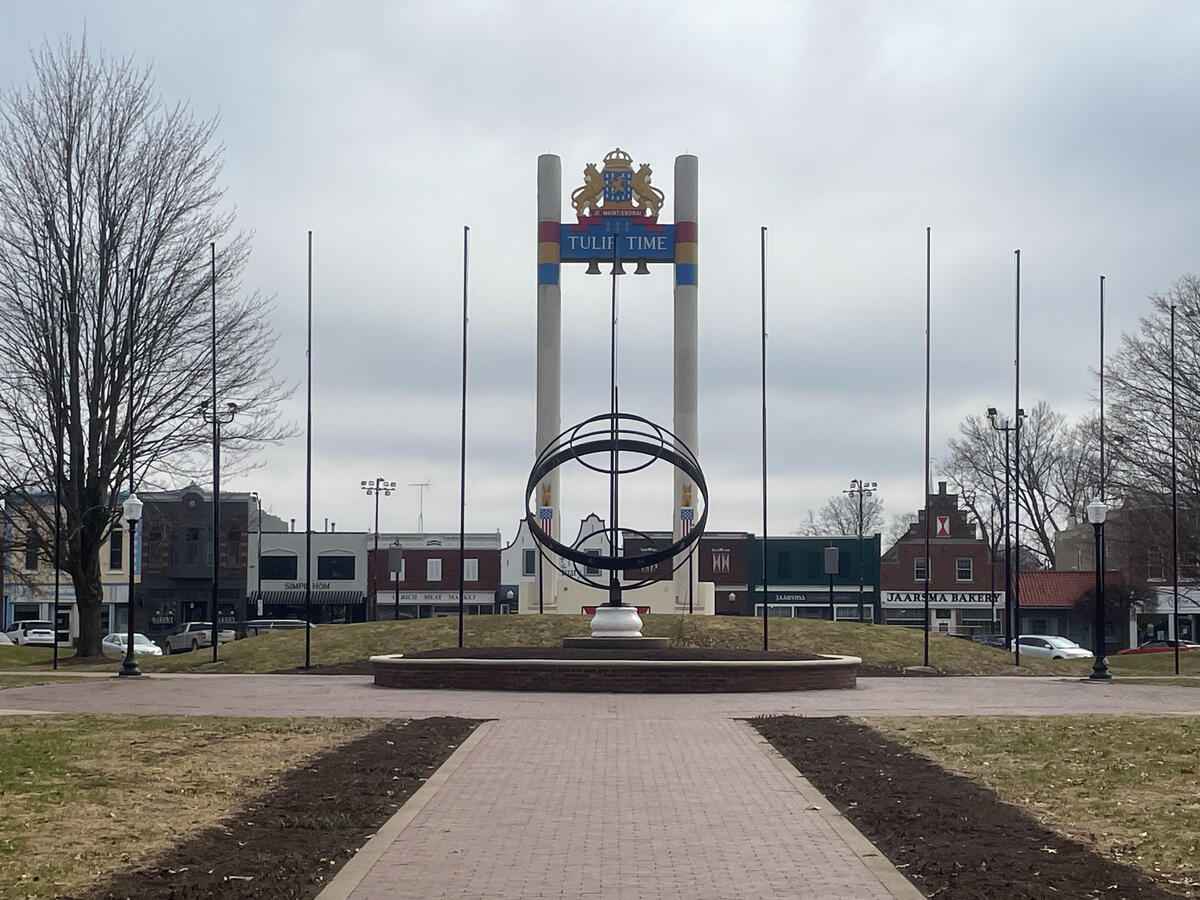 Tall Tulip Time sign and central sculpture in Pella’s town square on an overcast day.