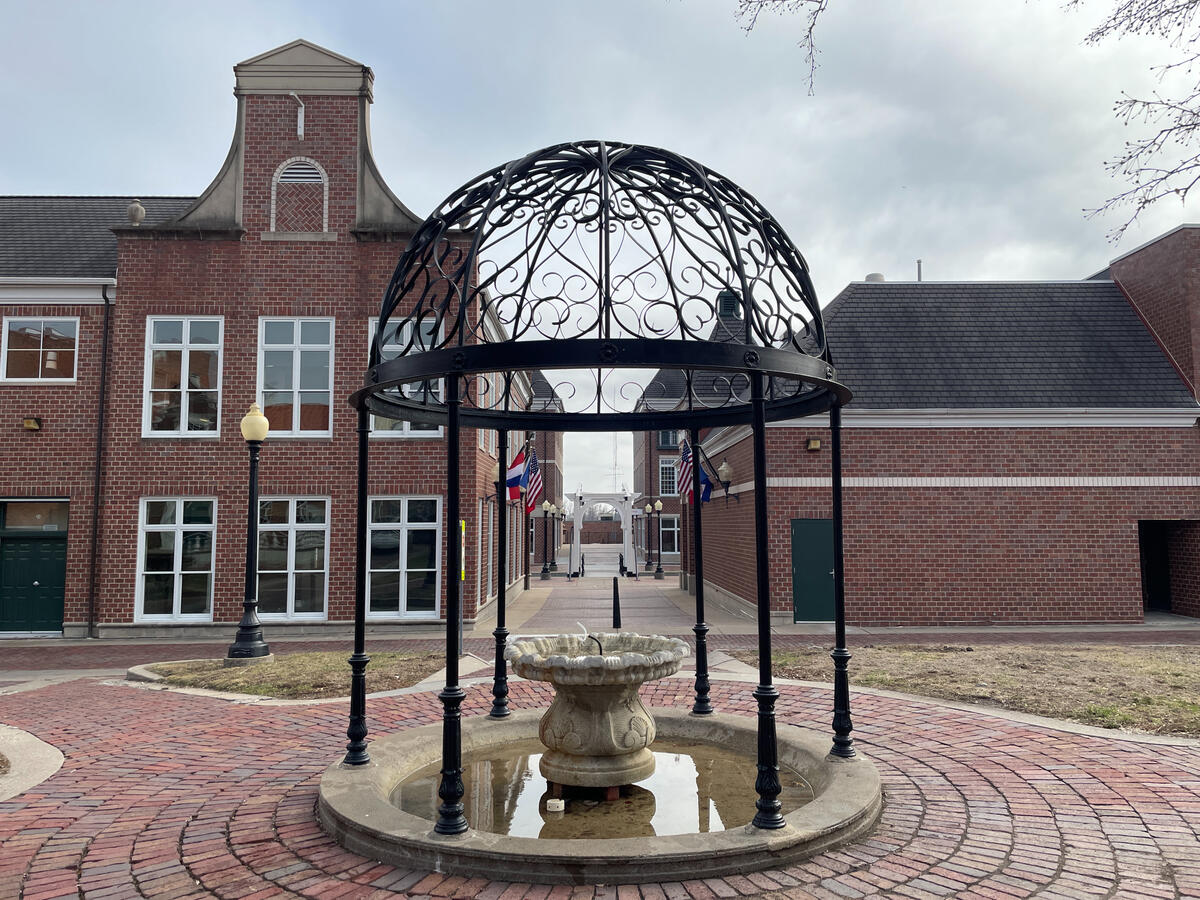 Courtyard near the Molengracht featuring a wrought‑iron dome structure and stone fountain basin.