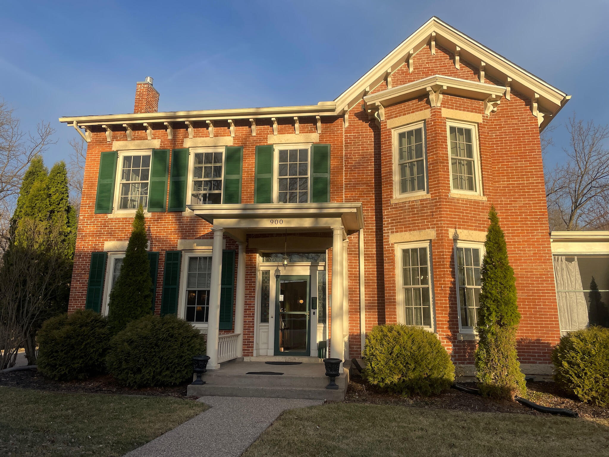 Exterior of the historic Aldrich Guest House at 900 3rd Street in Galena, Illinois, a red brick federal-style bed and breakfast with dark green shutters.