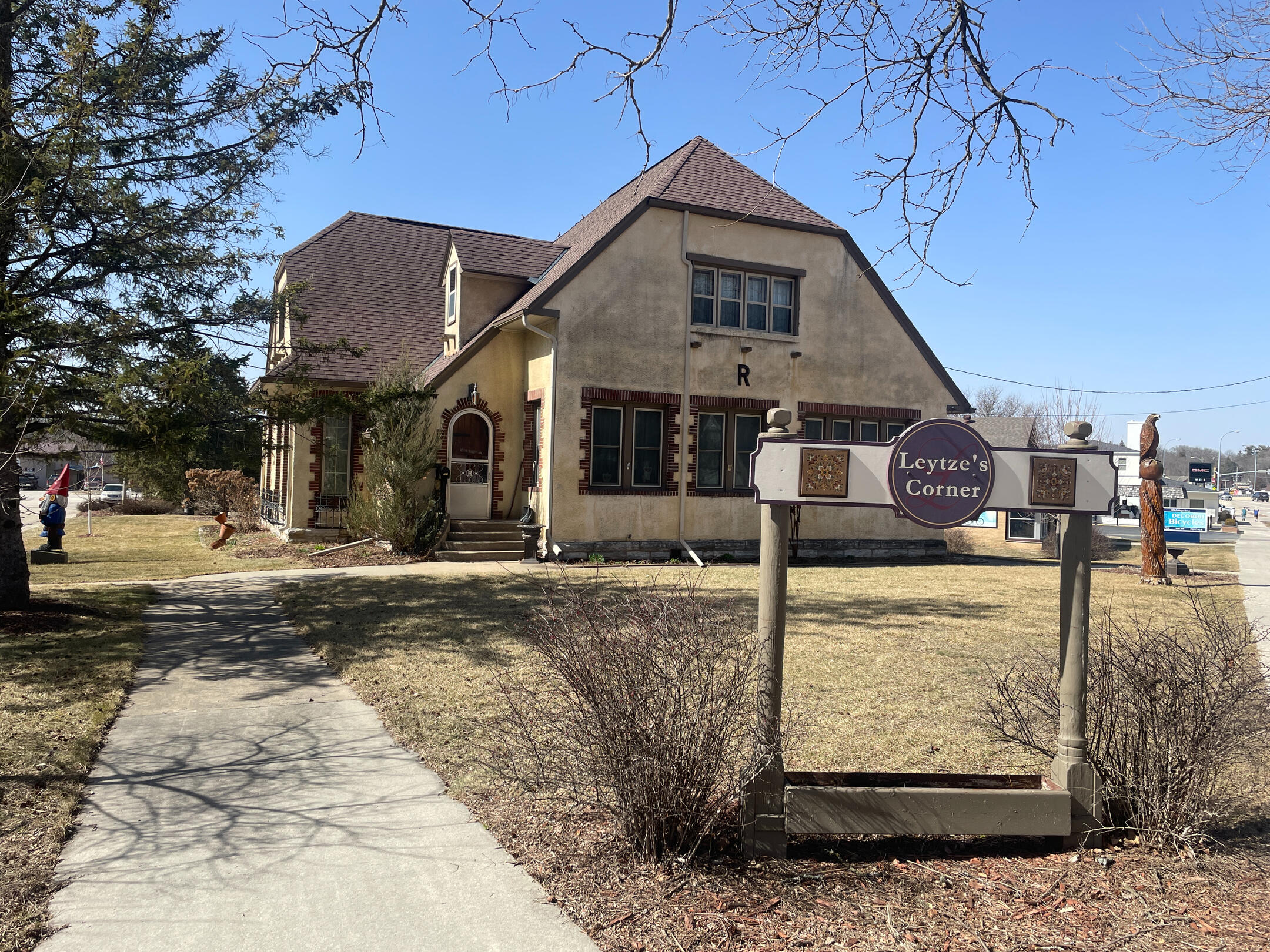 Corner‑lot stucco building with brown trim and a front sign for Leytze’s Corner Bed and Bath in Decorah.