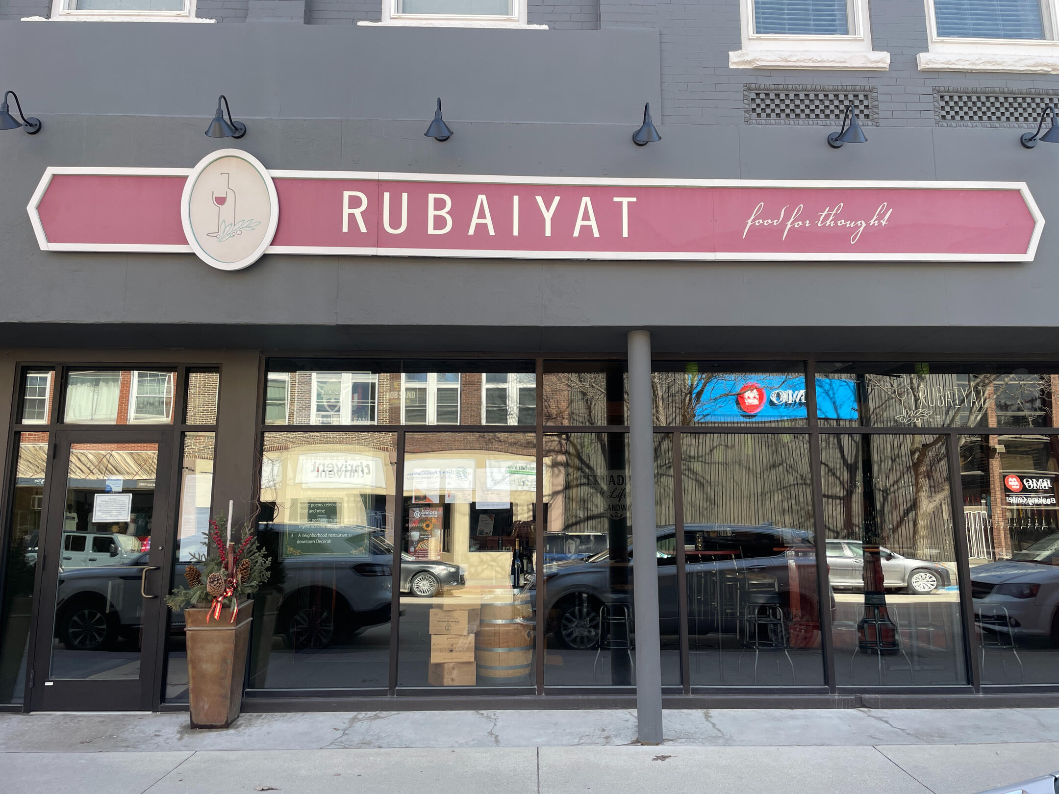 Rubaiyat Restaurant storefront with large front windows and a maroon sign above the entrance in downtown Decorah.